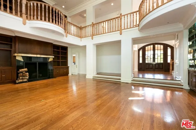 a view of a livingroom with wooden floor and a fireplace