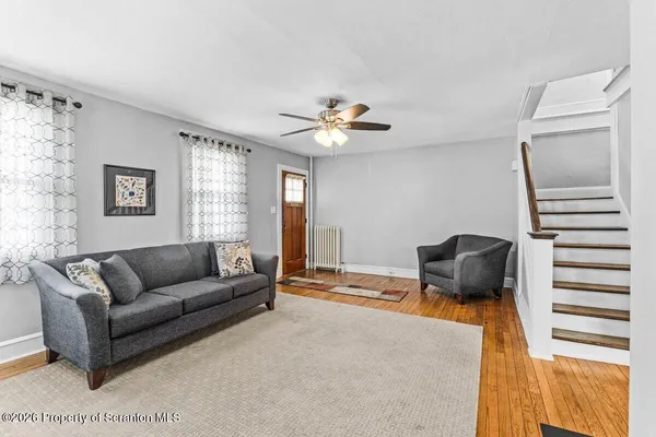 a living room with furniture and a ceiling fan