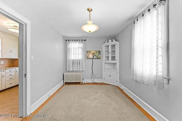 a view of a livingroom with wooden floor and windows