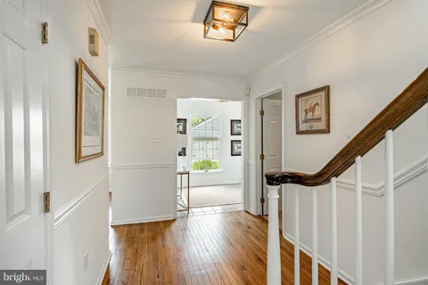 a view of hallway with stairs and wooden floor
