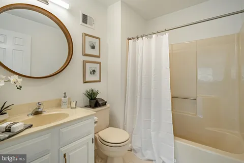 a bathroom with a granite countertop sink toilet and a mirror