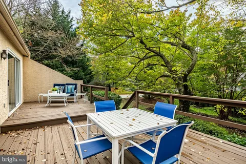 a view of a patio with table and chairs a barbeque with wooden fence and floor