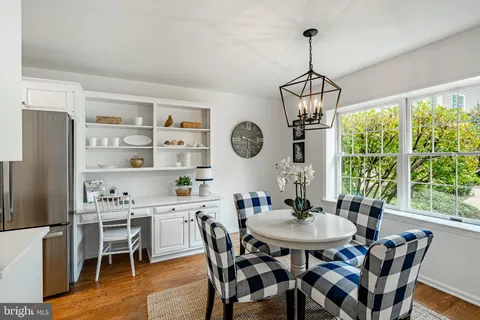 a dining room with furniture a chandelier and wooden floor