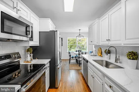 a kitchen with a sink a stove and cabinets