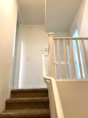 a view of staircase with white walls and a window