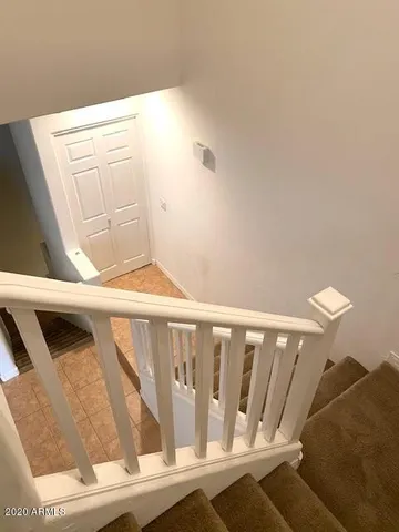 a view of staircase with railing and white walls