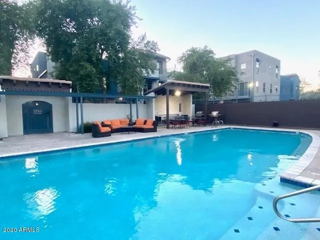 swimming pool view with a seating space and a garden
