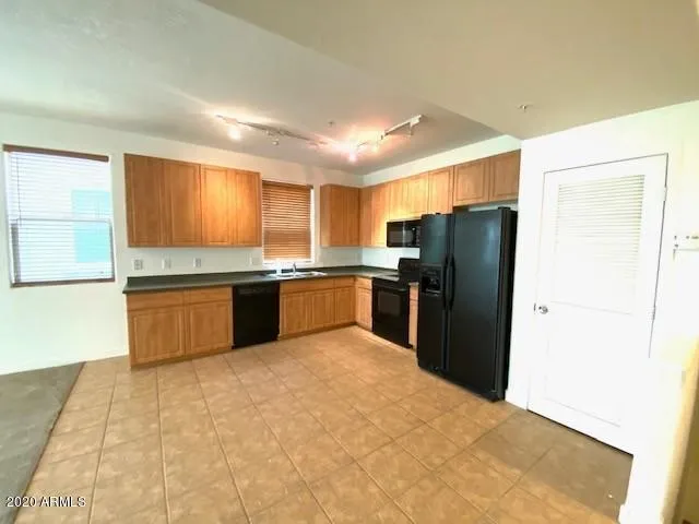 a kitchen with stainless steel appliances granite countertop a refrigerator sink and cabinets