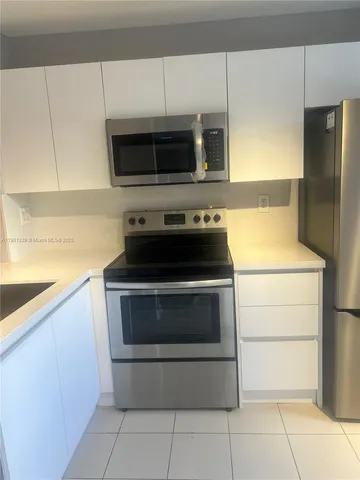 a stove top oven sitting inside of a kitchen