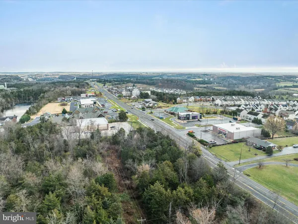 an aerial view of residential houses with outdoor space and trees
