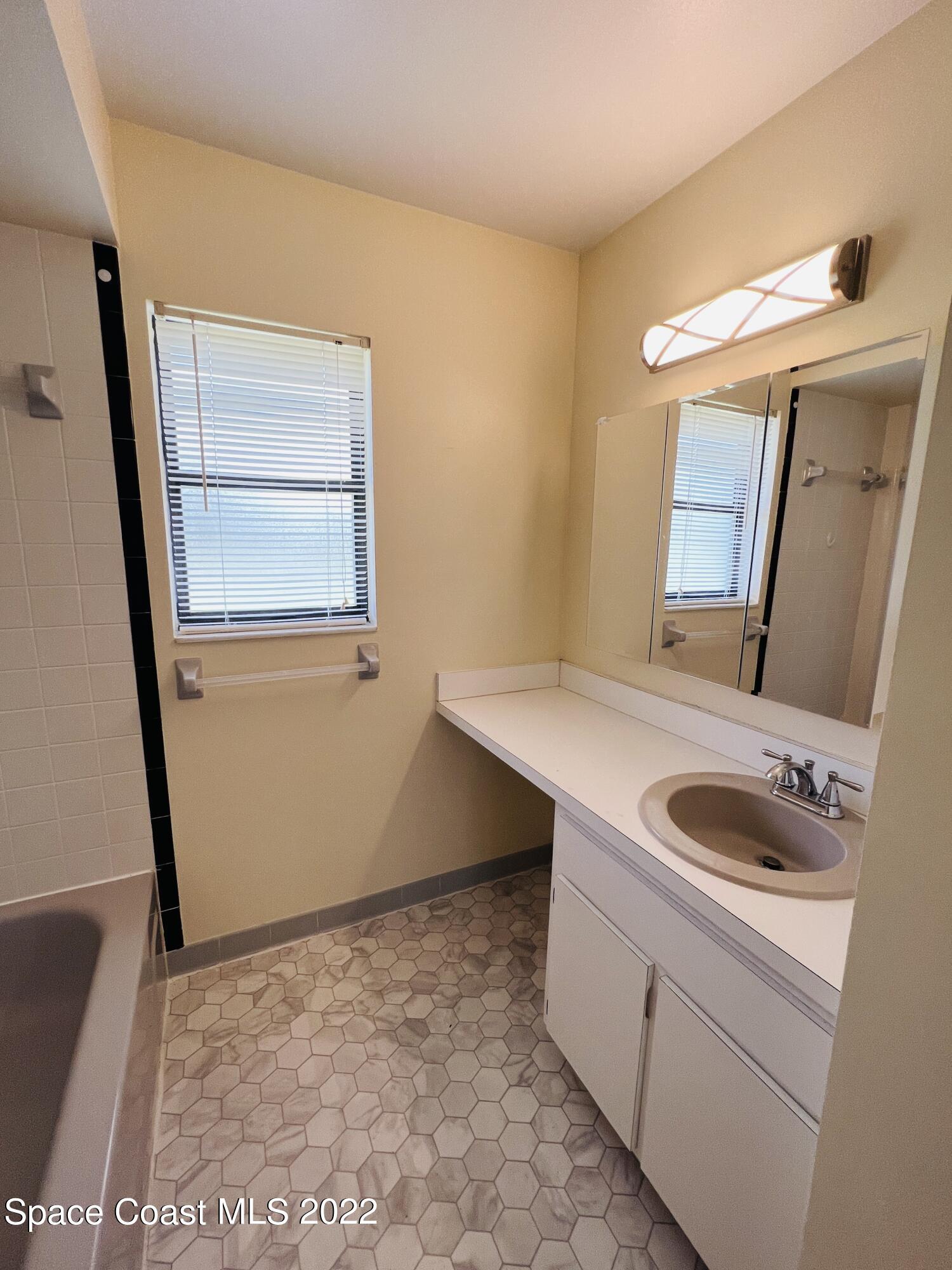 4897 Bridge Road Cocoa, FL 32927 - Photo 10 of 12 a bathroom with a sink and a mirror