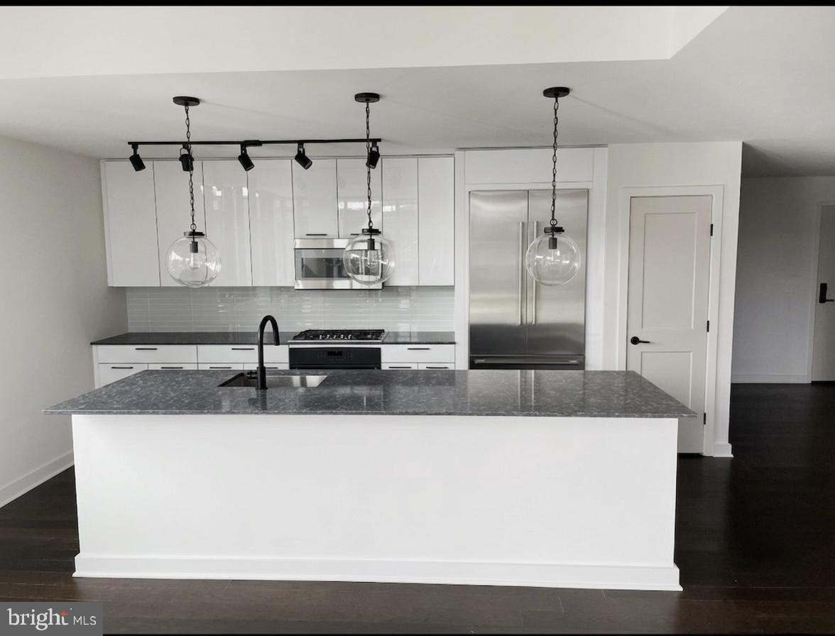 70 N Street Southeast, Unit N301 Washington, DC 20003 - Photo 4 of 47 a large kitchen with granite countertop a sink and white cabinets