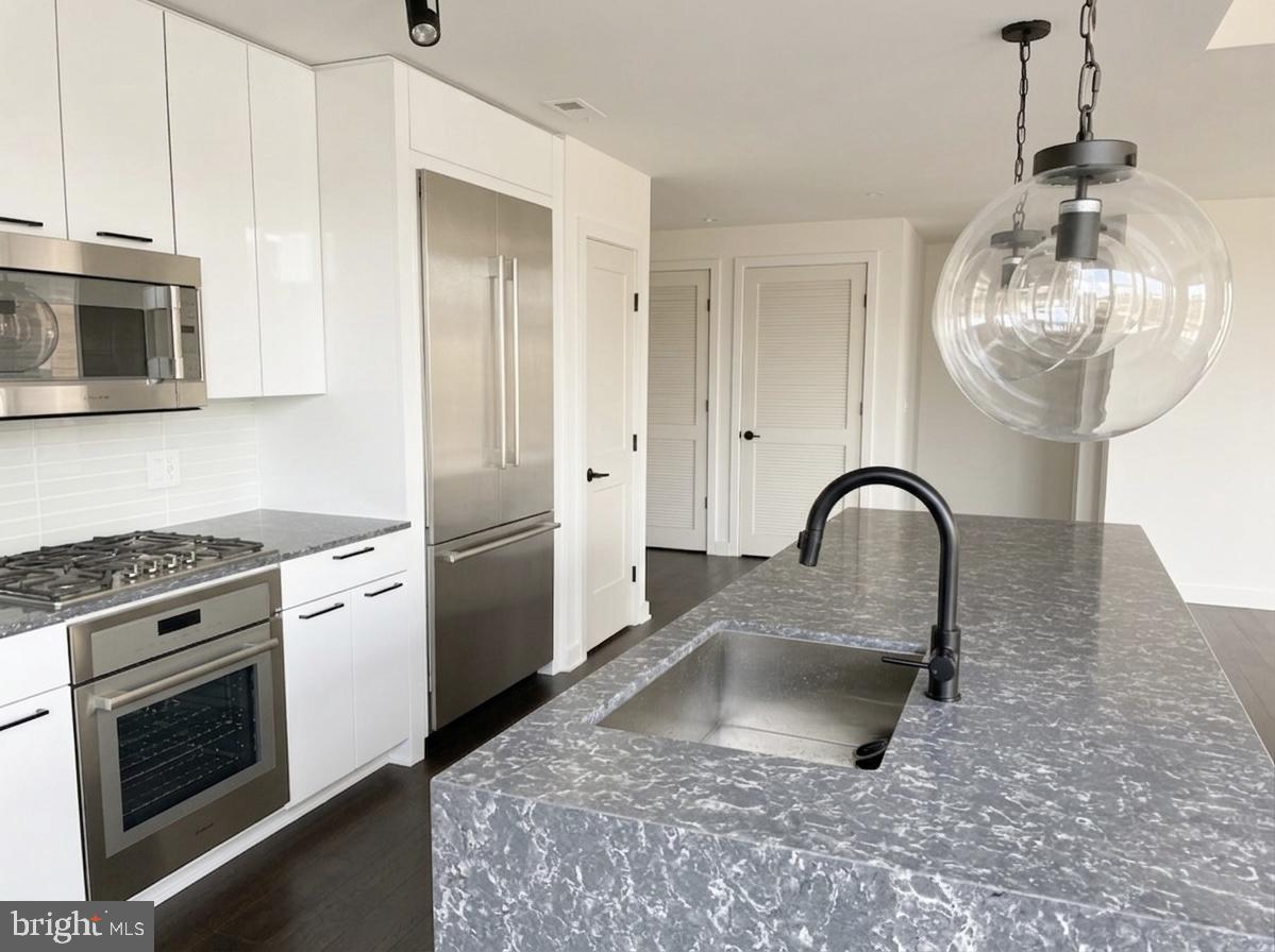 70 N Street Southeast, Unit N301 Washington, DC 20003 - Photo 7 of 47 a kitchen with stainless steel appliances granite countertop a sink a stove a refrigerator cabinets and a dining table