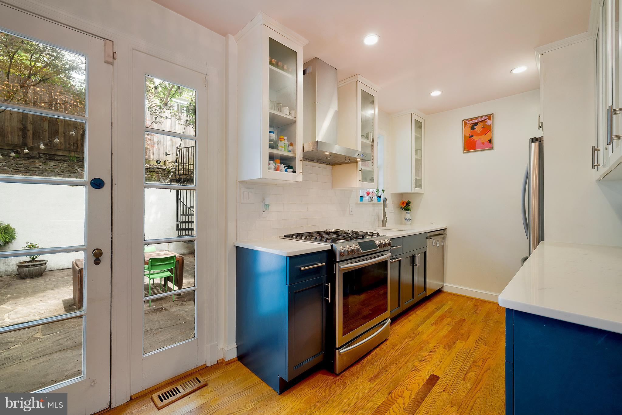 2135 Tunlaw Road Northwest Washington, DC 20007 - Photo 11 of 48 a kitchen with stainless steel appliances granite countertop a stove and a refrigerator