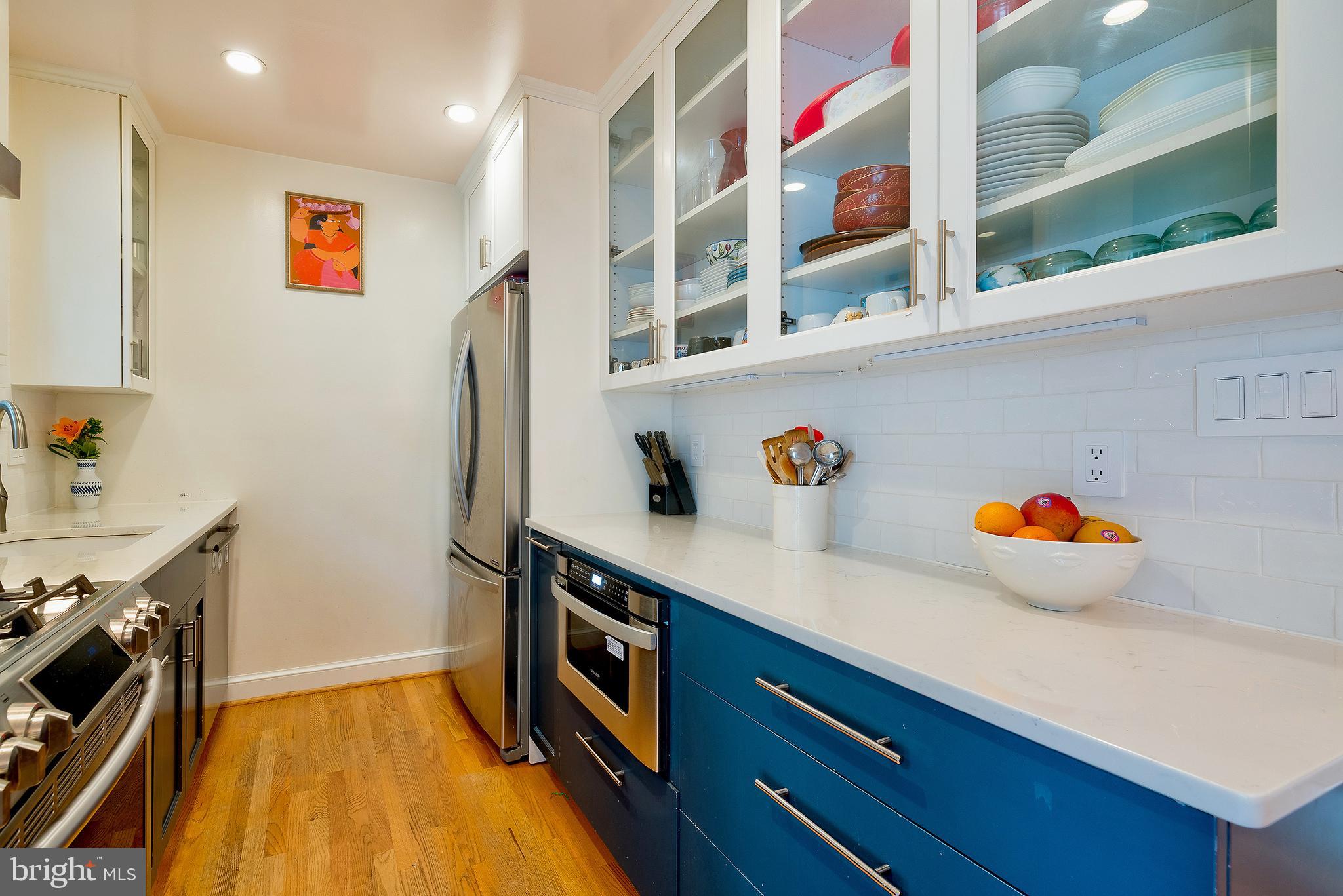 2135 Tunlaw Road Northwest Washington, DC 20007 - Photo 13 of 48 a kitchen with stainless steel appliances a sink a refrigerator and wooden floor