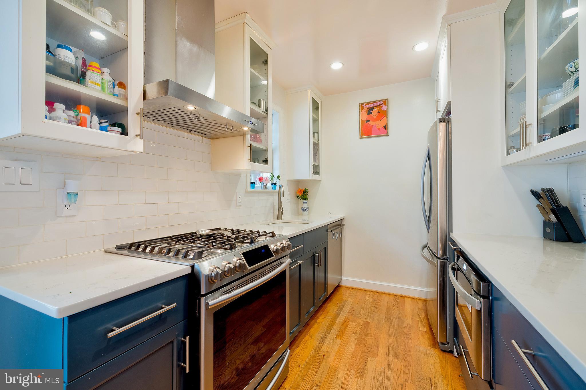 2135 Tunlaw Road Northwest Washington, DC 20007 - Photo 14 of 48 a kitchen with stainless steel appliances a stove and a refrigerator
