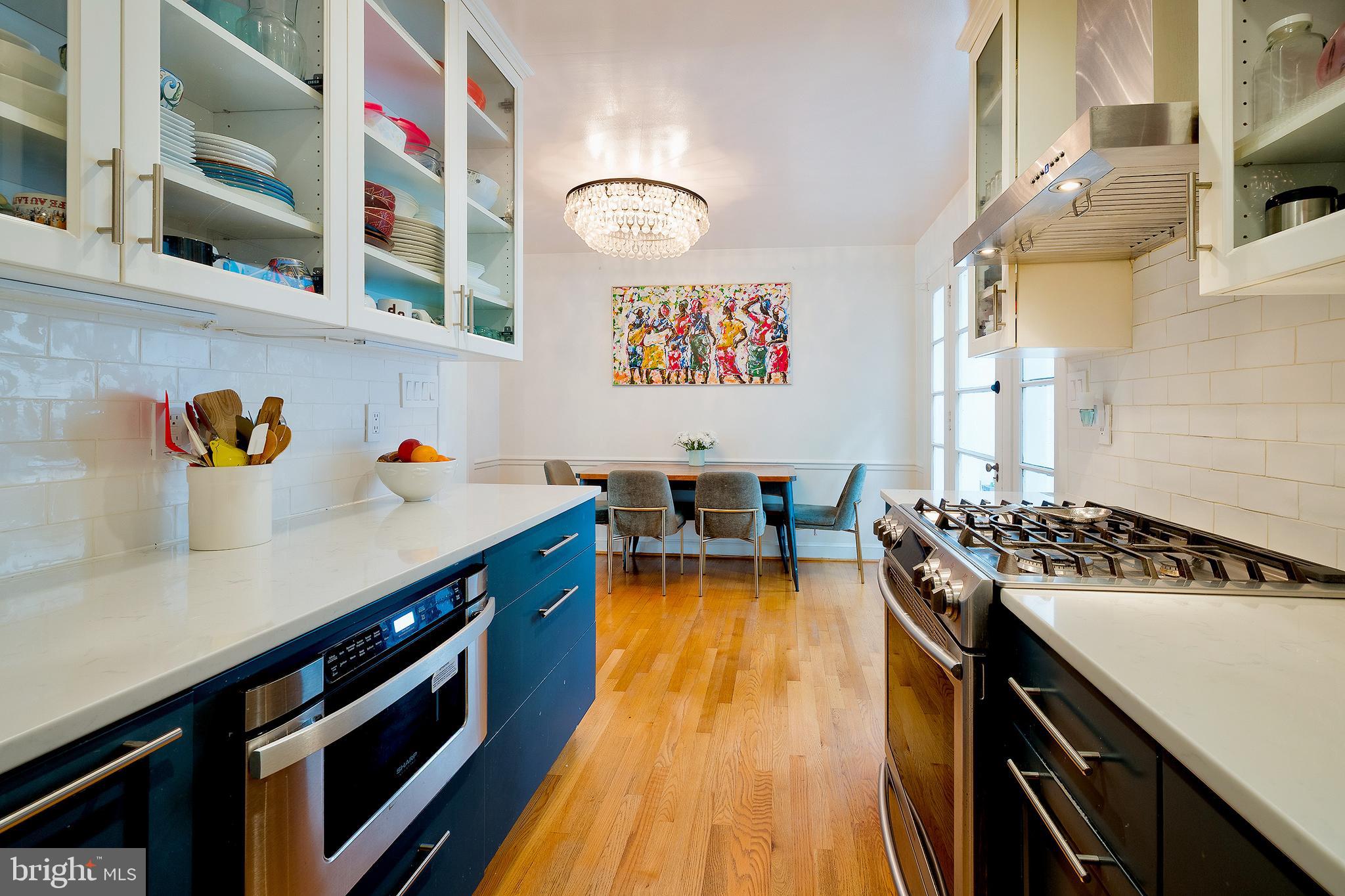 2135 Tunlaw Road Northwest Washington, DC 20007 - Photo 16 of 48 a kitchen with a stove and a wooden floor