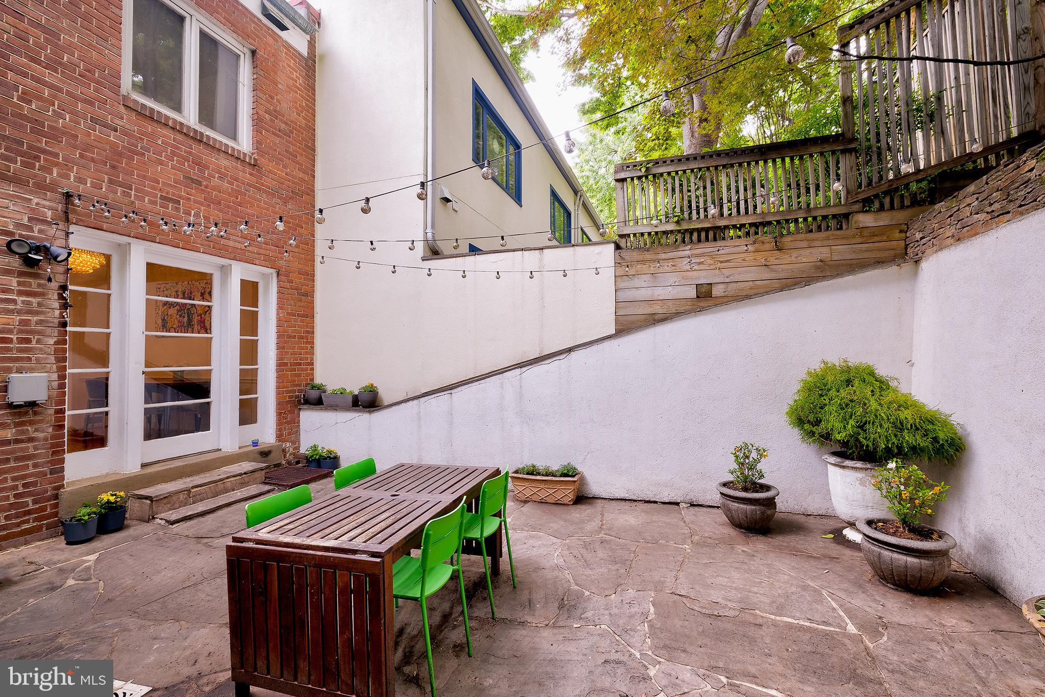 2135 Tunlaw Road Northwest Washington, DC 20007 - Photo 22 of 48 a backyard of a house with table and chairs potted plants