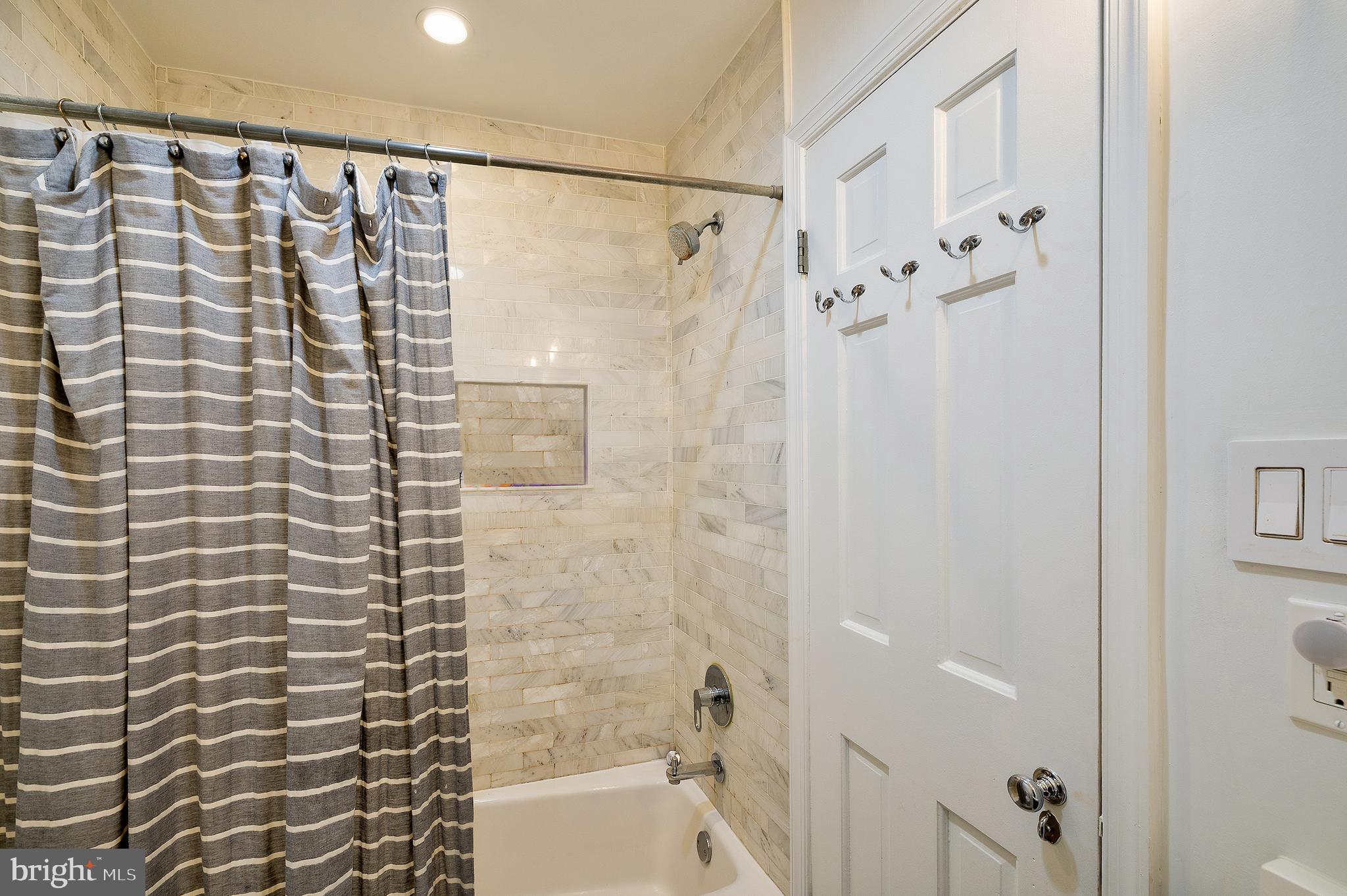 2135 Tunlaw Road Northwest Washington, DC 20007 - Photo 28 of 48 a bathroom with a shower curtain and a shower
