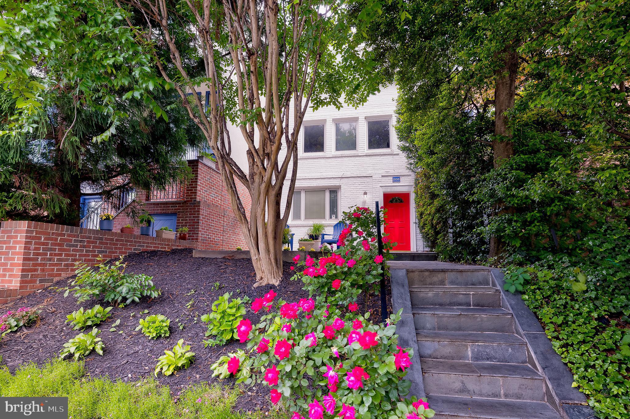 2135 Tunlaw Road Northwest Washington, DC 20007 - Photo 40 of 48 a front view of a house with lots of flower and trees