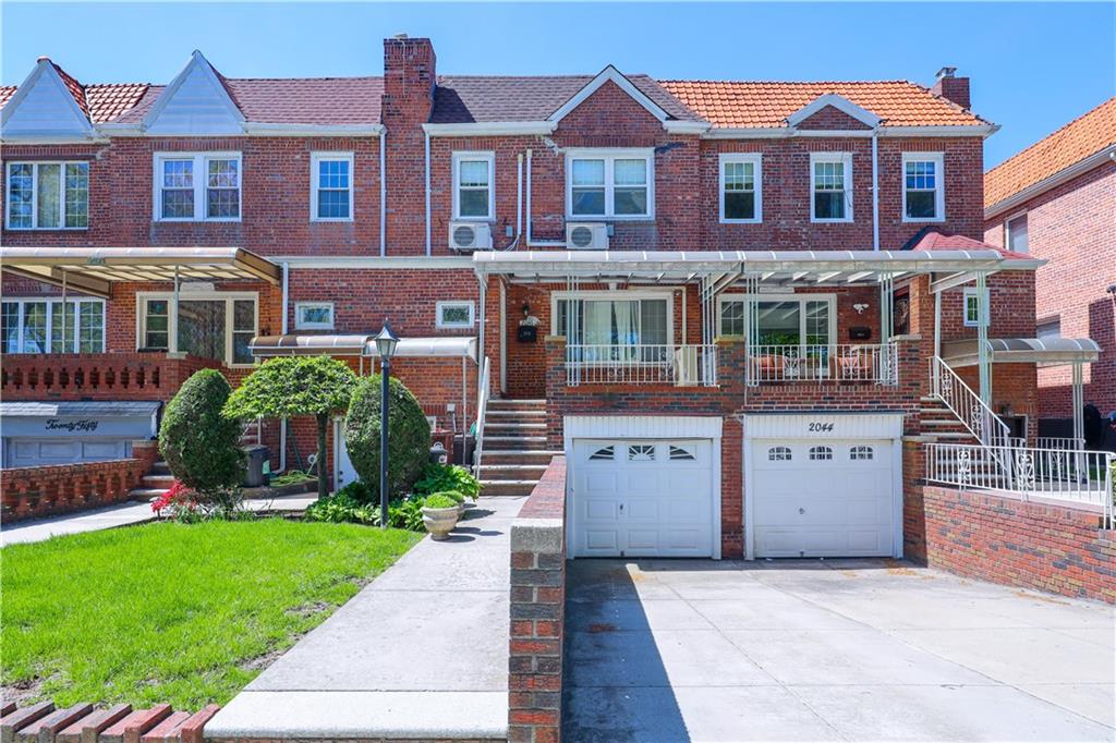 a front view of a house with a yard and a garage