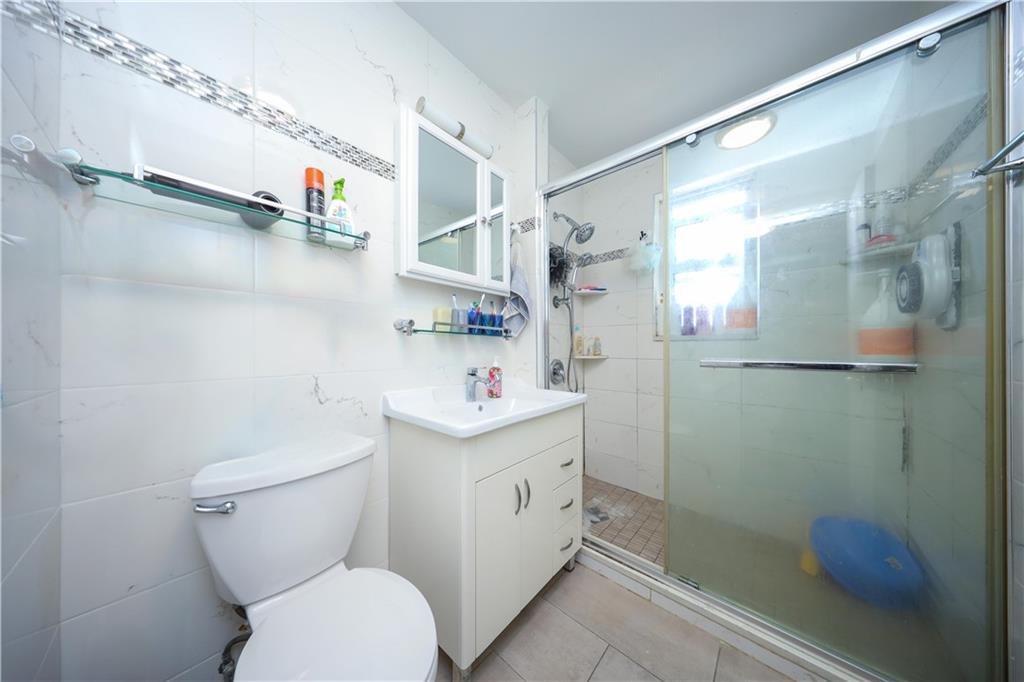 2046 Stuart Street Brooklyn, NY 11229 - Photo 15 of 27 a bathroom with a sink a toilet and shower