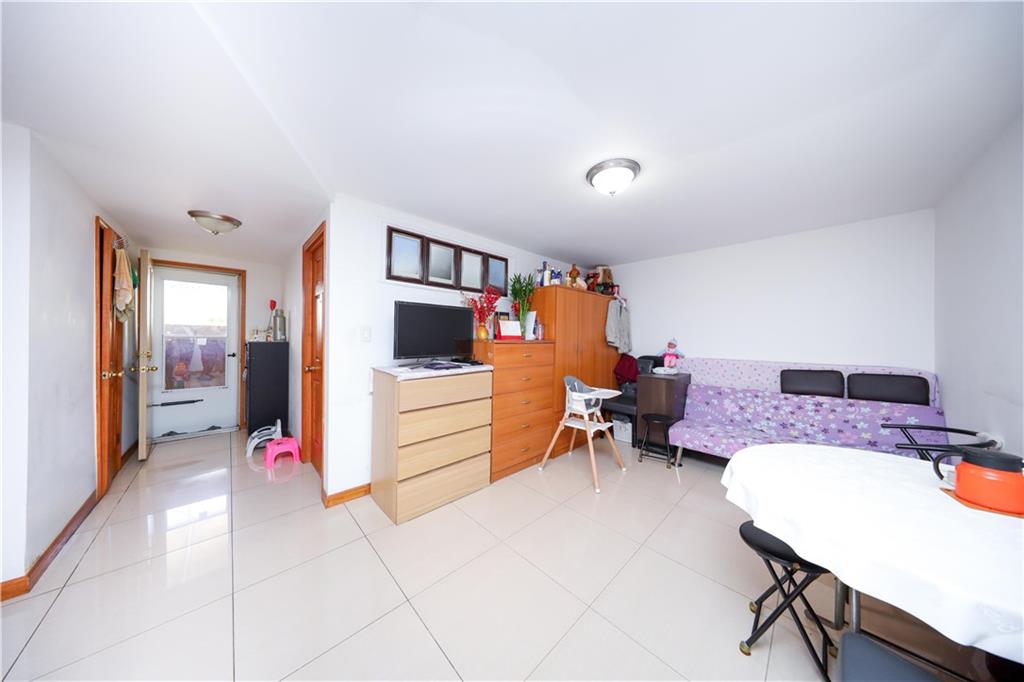2046 Stuart Street Brooklyn, NY 11229 - Photo 16 of 27 a living room with furniture and a flat screen tv