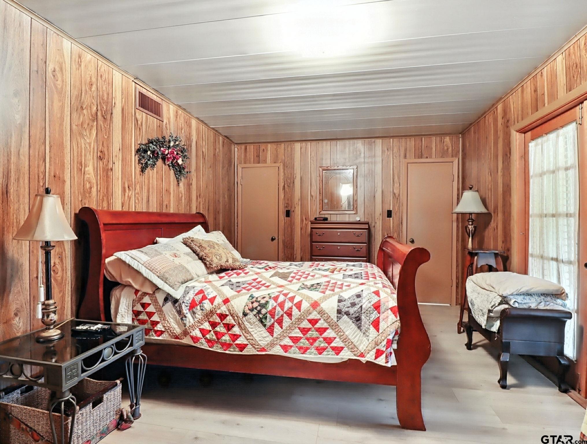 402 Watson Road Gladewater, TX 75647 - Photo 15 of 32 a bedroom with a bed and a chandelier