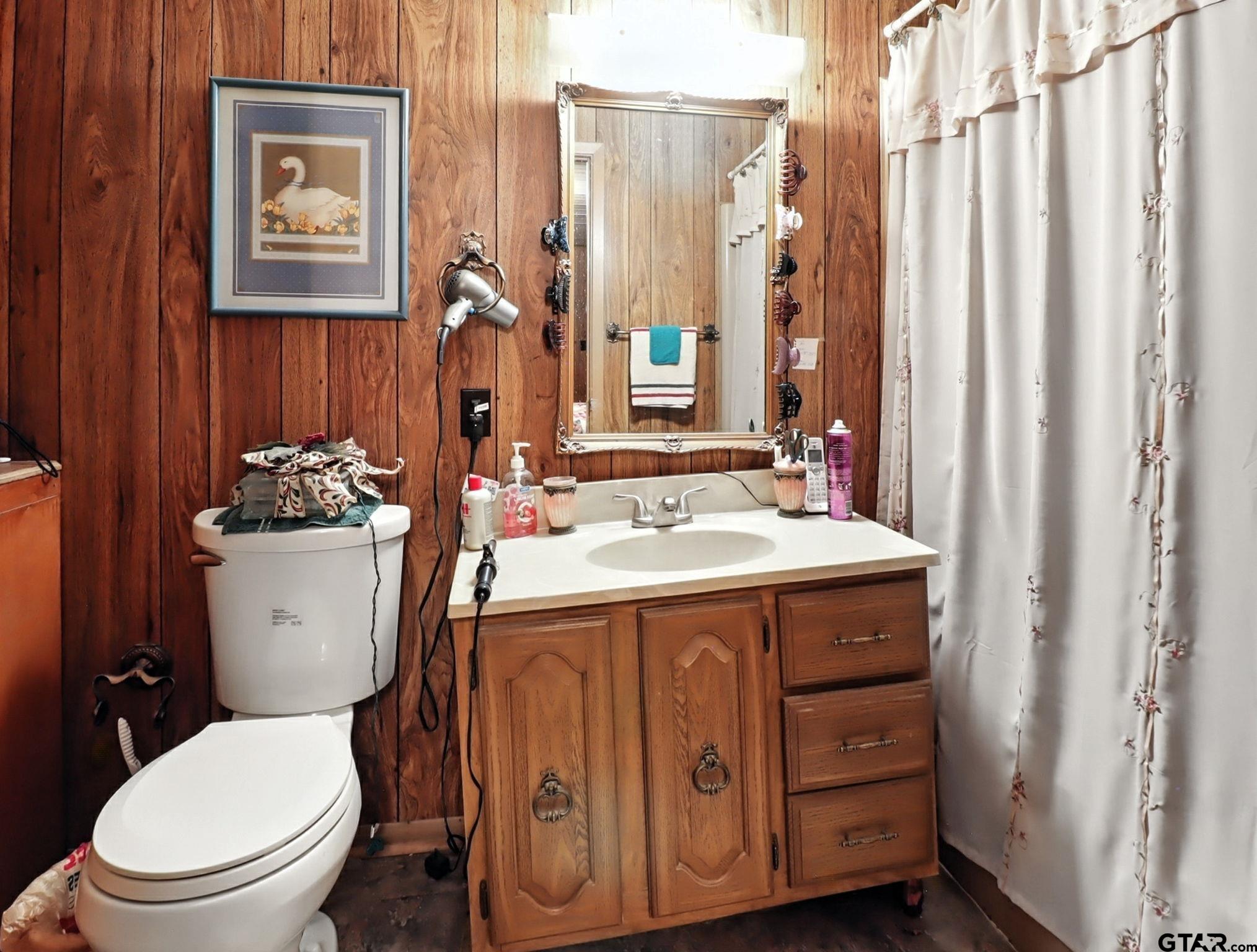 402 Watson Road Gladewater, TX 75647 - Photo 16 of 32 a bathroom with a sink a toilet and a mirror