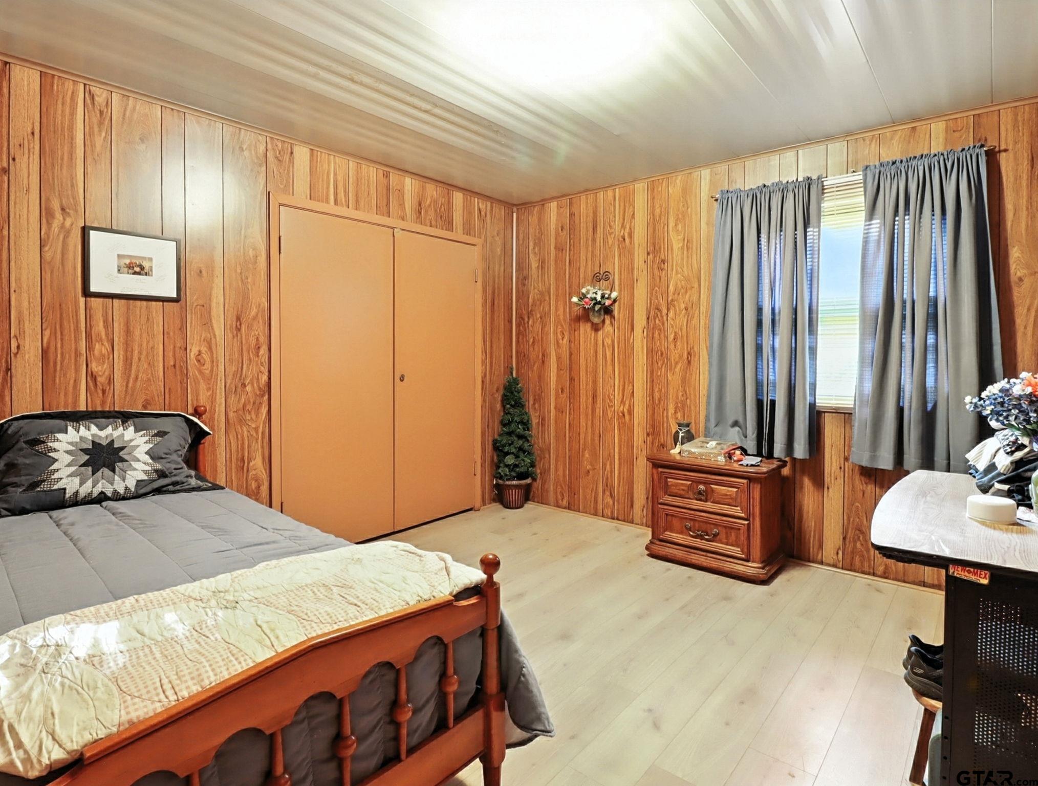 402 Watson Road Gladewater, TX 75647 - Photo 18 of 32 a bedroom with a large bed and a chair