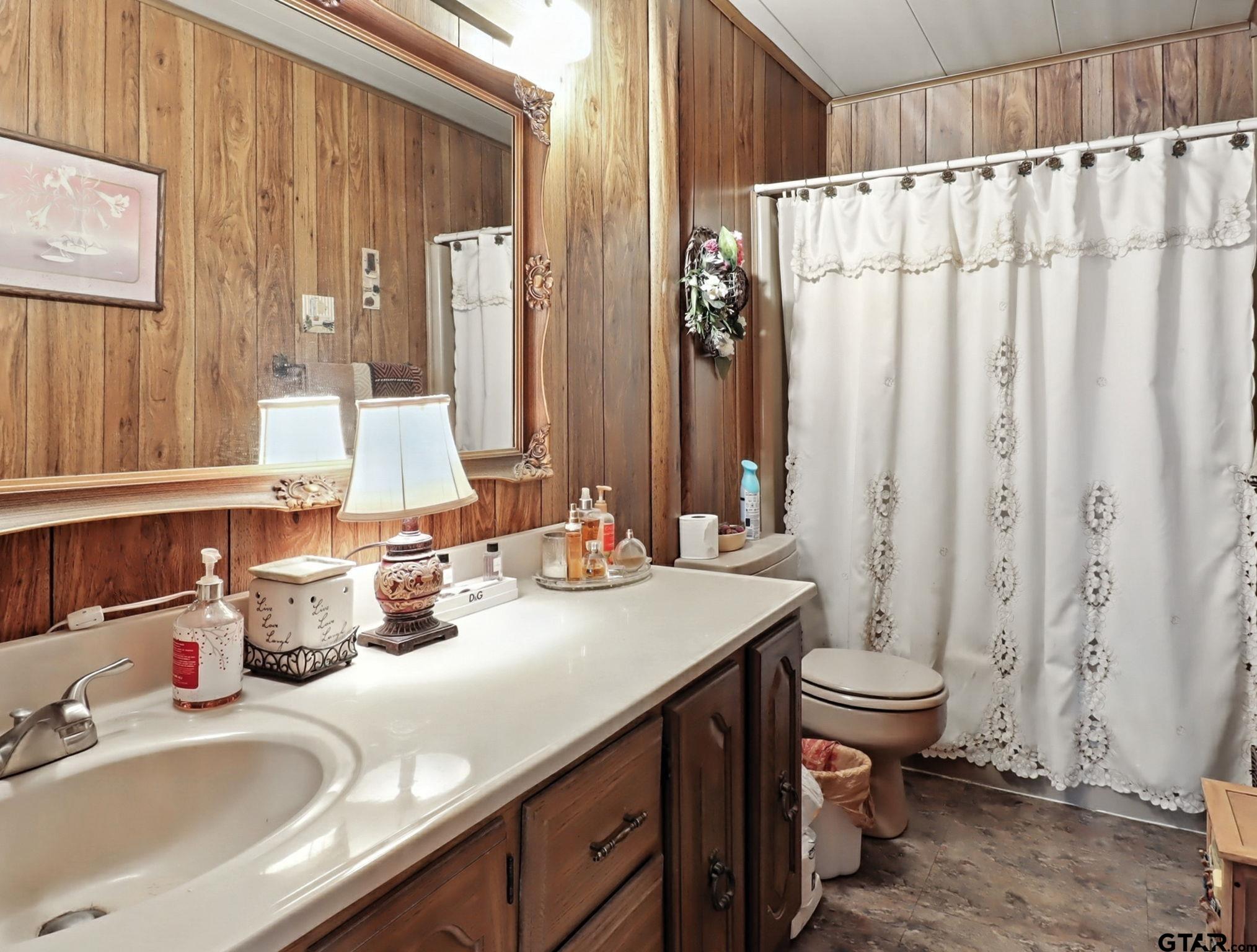 402 Watson Road Gladewater, TX 75647 - Photo 19 of 32 a bathroom with a double vanity sink and a mirror