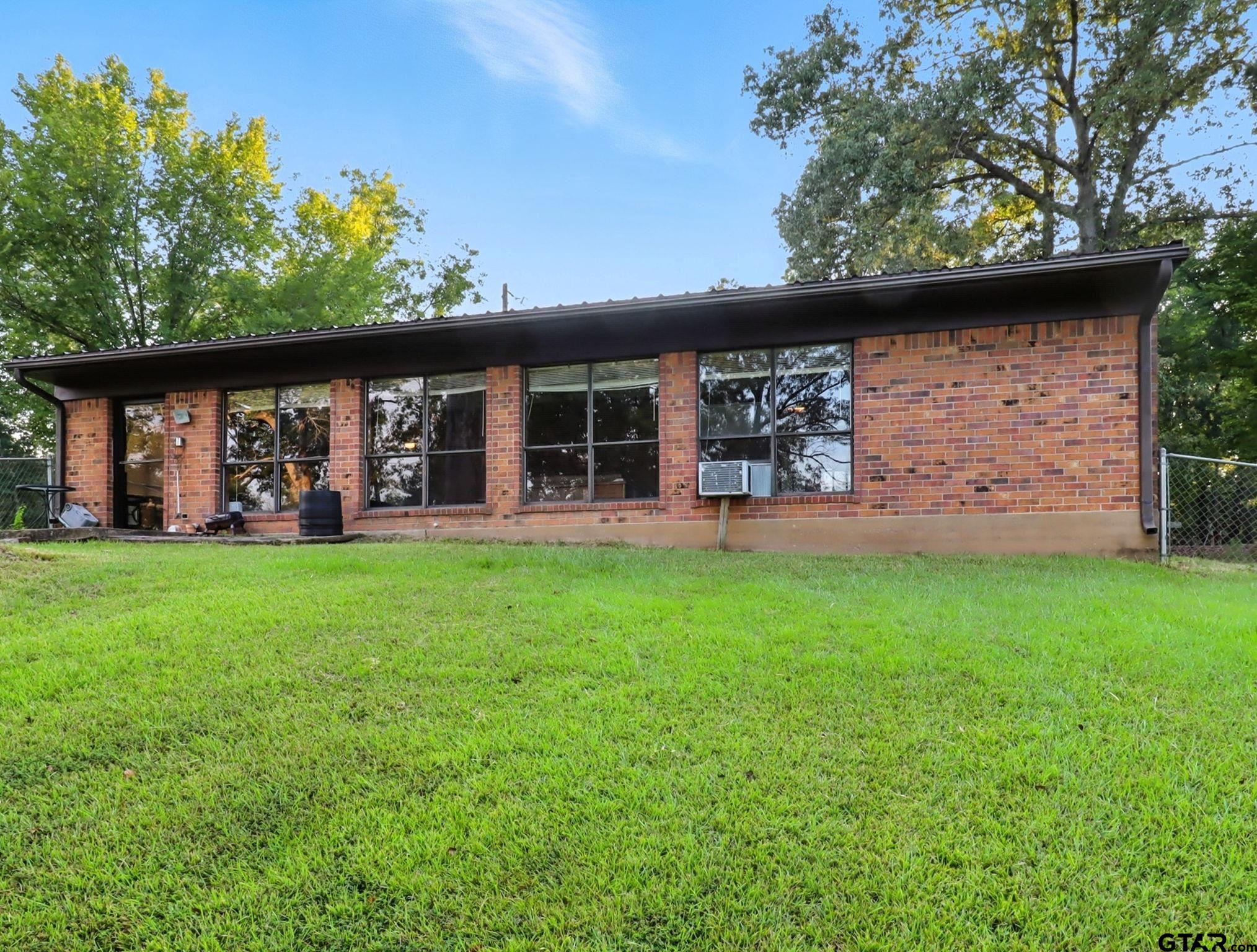 402 Watson Road Gladewater, TX 75647 - Photo 21 of 32 a view of a house with backyard and porch