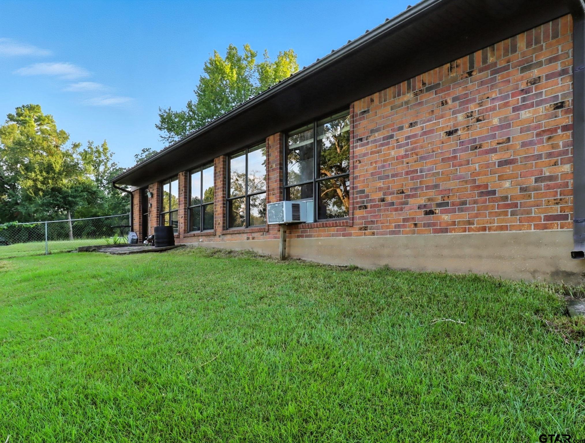 402 Watson Road Gladewater, TX 75647 - Photo 22 of 32 a view of a house with backyard and a garden