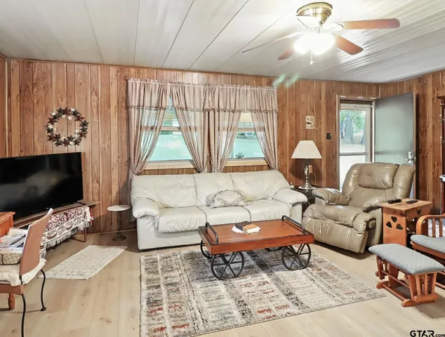 a living room with furniture a flat screen tv and a large window