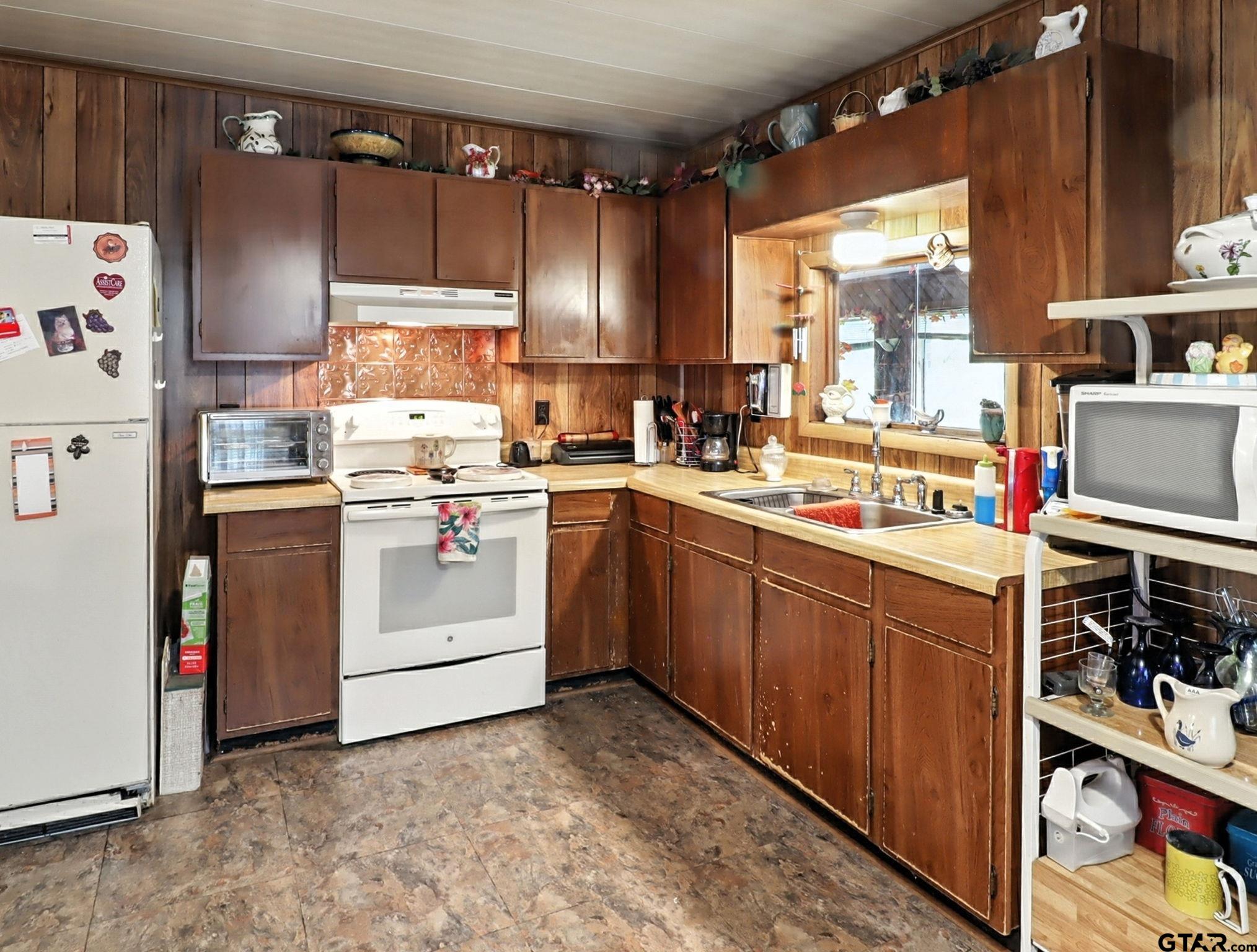402 Watson Road Gladewater, TX 75647 - Photo 7 of 32 a kitchen with a sink stove and cabinets