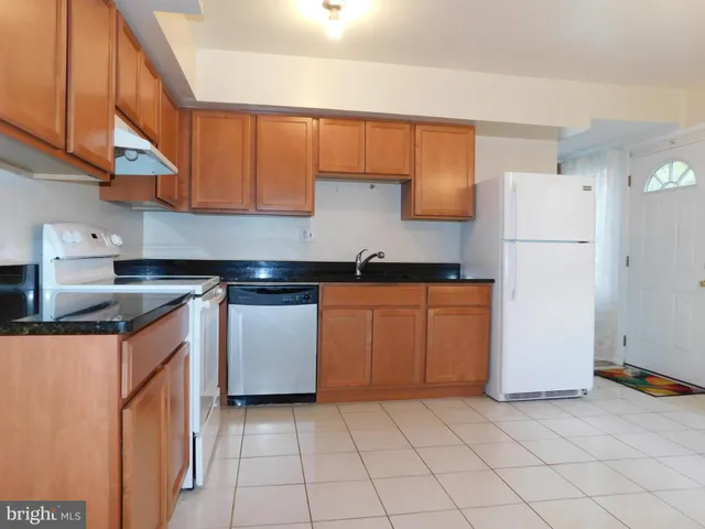 a kitchen with a sink a refrigerator and a cabinets