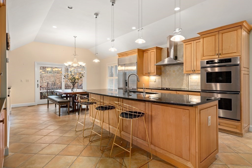 71 Sevland Road Newton, MA 02459 - Photo 8 of 28 a kitchen with stainless steel appliances granite countertop a stove top oven a sink dishwasher a dining table and chairs with wooden floor