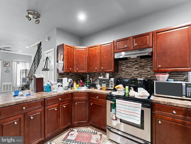a kitchen with a refrigerator and a stove top oven