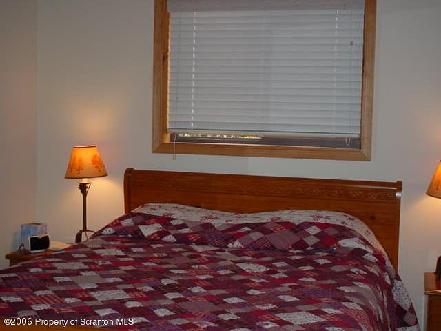 2338 Brookfield Road Lake Ariel, PA 18436 - Photo 6 of 9 a view of a bedroom with a bed and a lamp on table