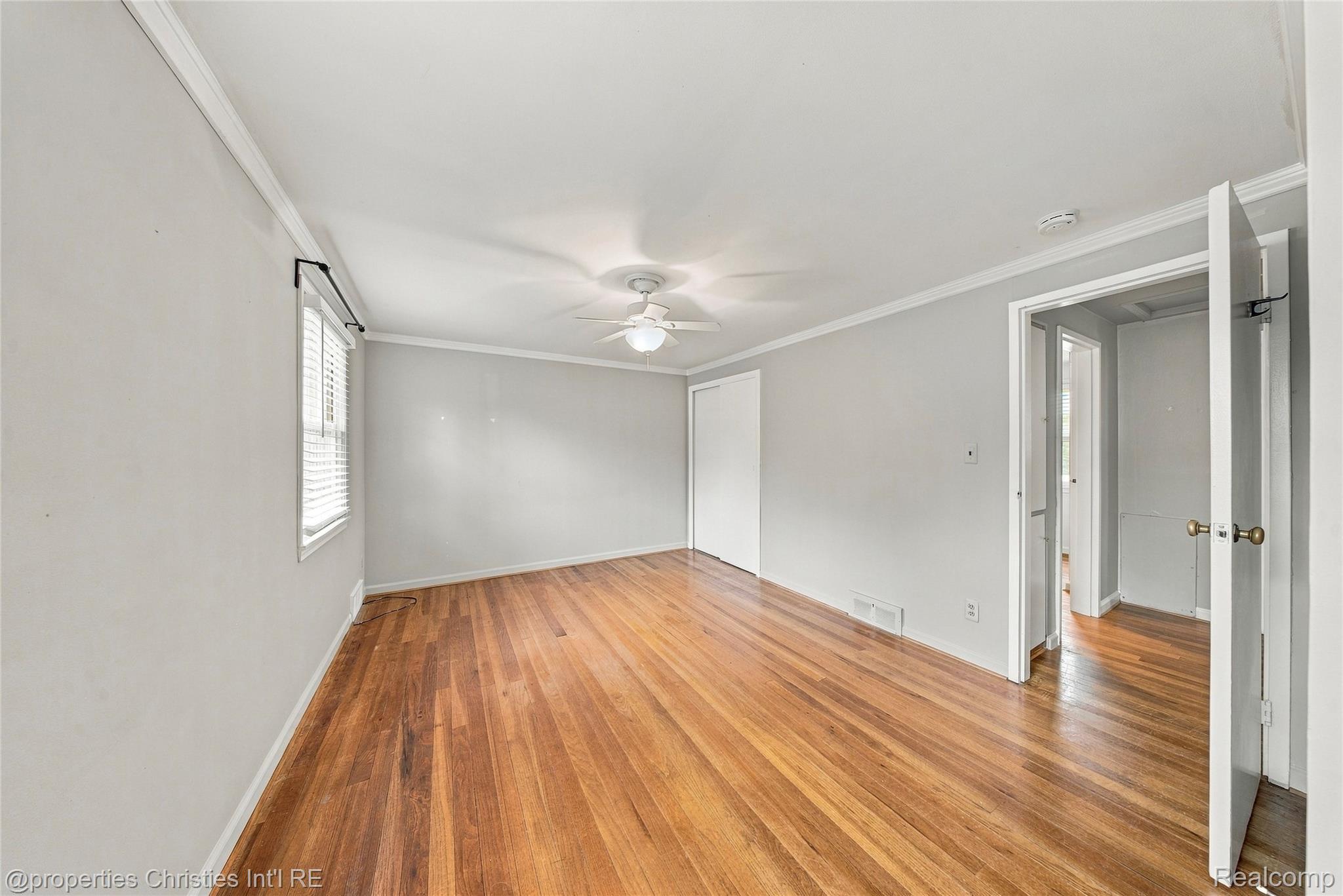 1642 Graefield Road, Unit 75 Birmingham, MI 48009 - Photo 14 of 25 Hardwood flooring, ceiling fan with integrated lighting, white interior doors, window with blinds, and crown molding