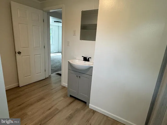 a kitchen with a sink and wooden floor