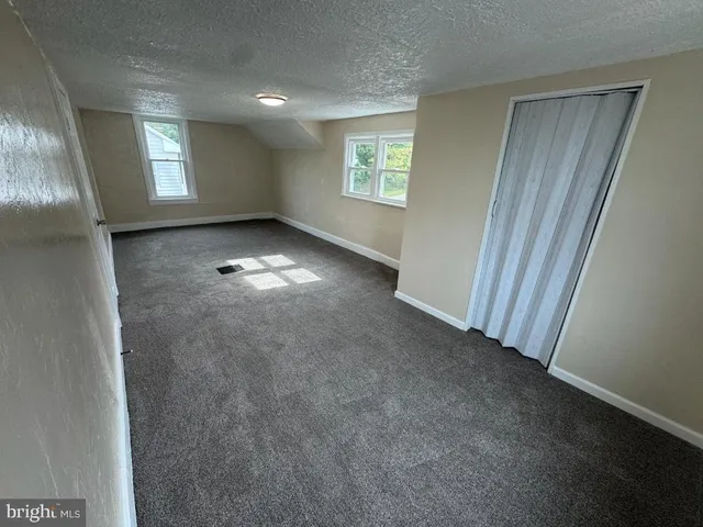 an empty room with windows and closet