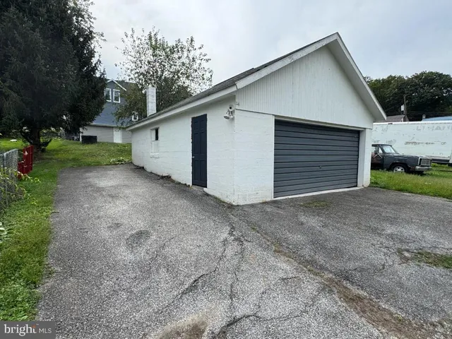 a small barn with a small yard and a large parking space