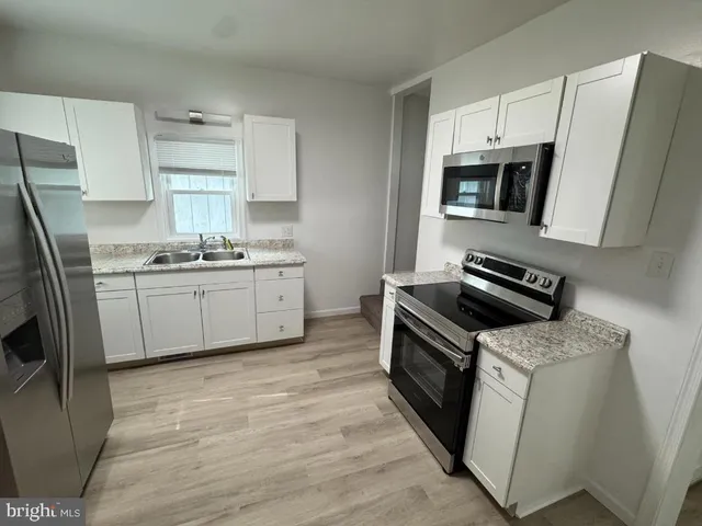 a kitchen with a sink appliances and cabinets