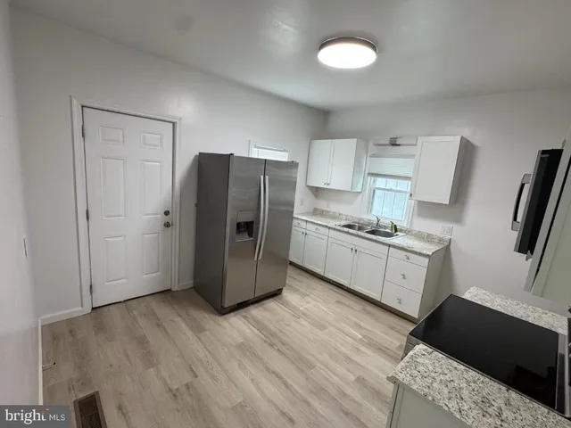 a kitchen with a refrigerator and a stove top oven