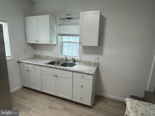 a room with granite countertop white cabinets and sink