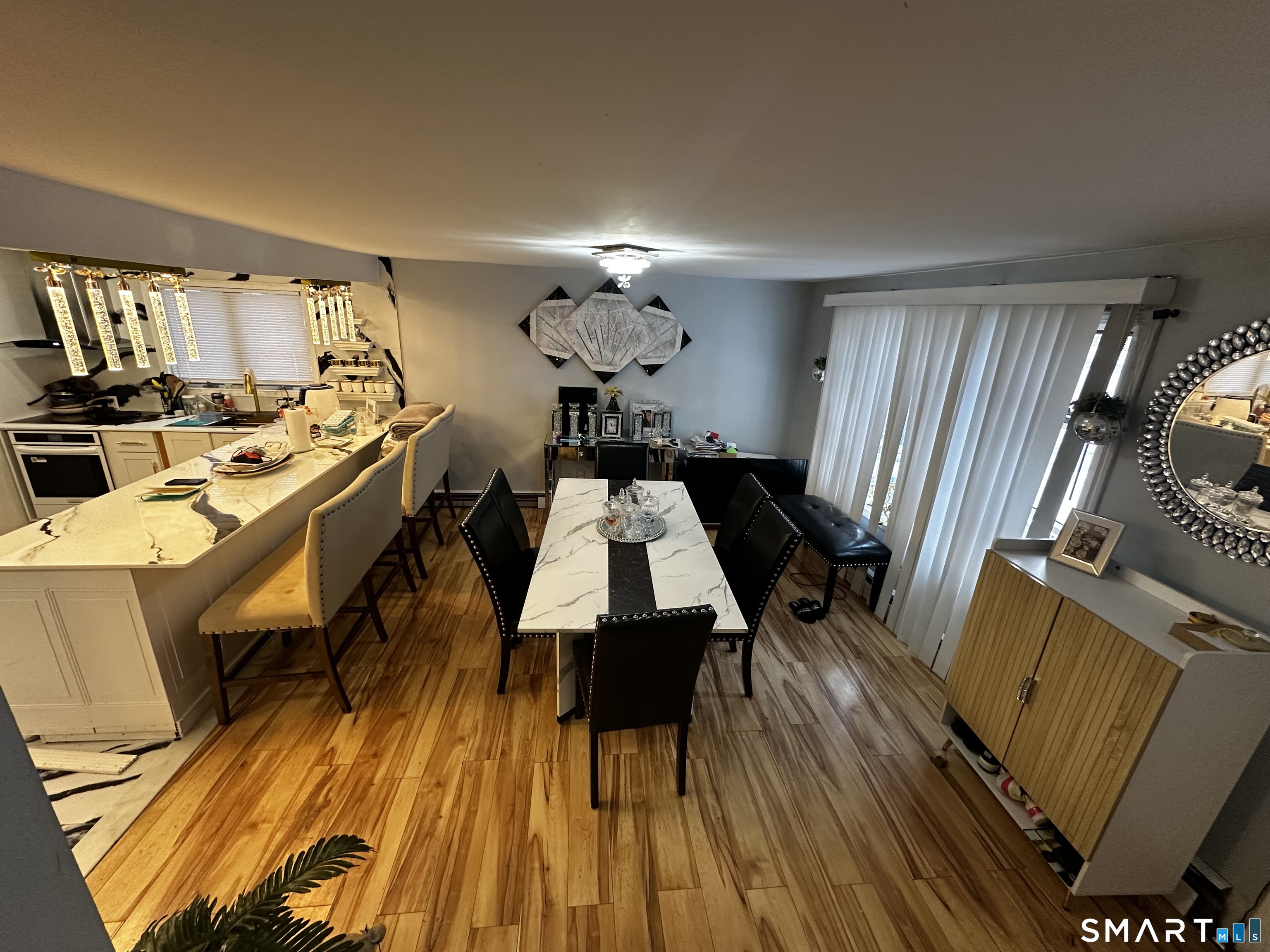 249 Wheeler Road Monroe, CT 06468 - Photo 13 of 39 a dining room with wooden floor a chandelier a wooden table and chairs