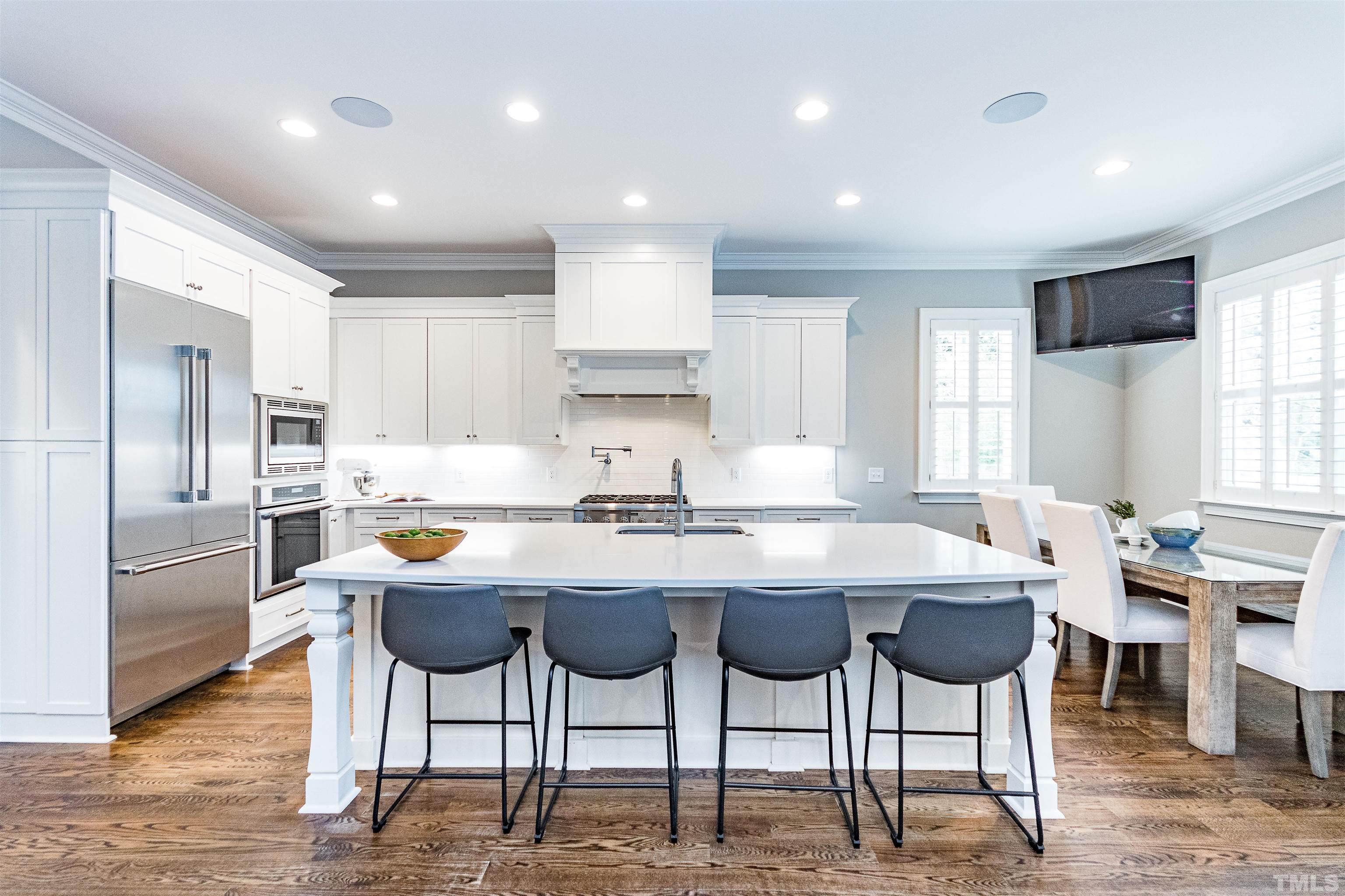 641 Cranbrook Road Raleigh, NC 27609 - Photo 11 of 39 a kitchen with stainless steel appliances kitchen island granite countertop a dining table chairs and refrigerator