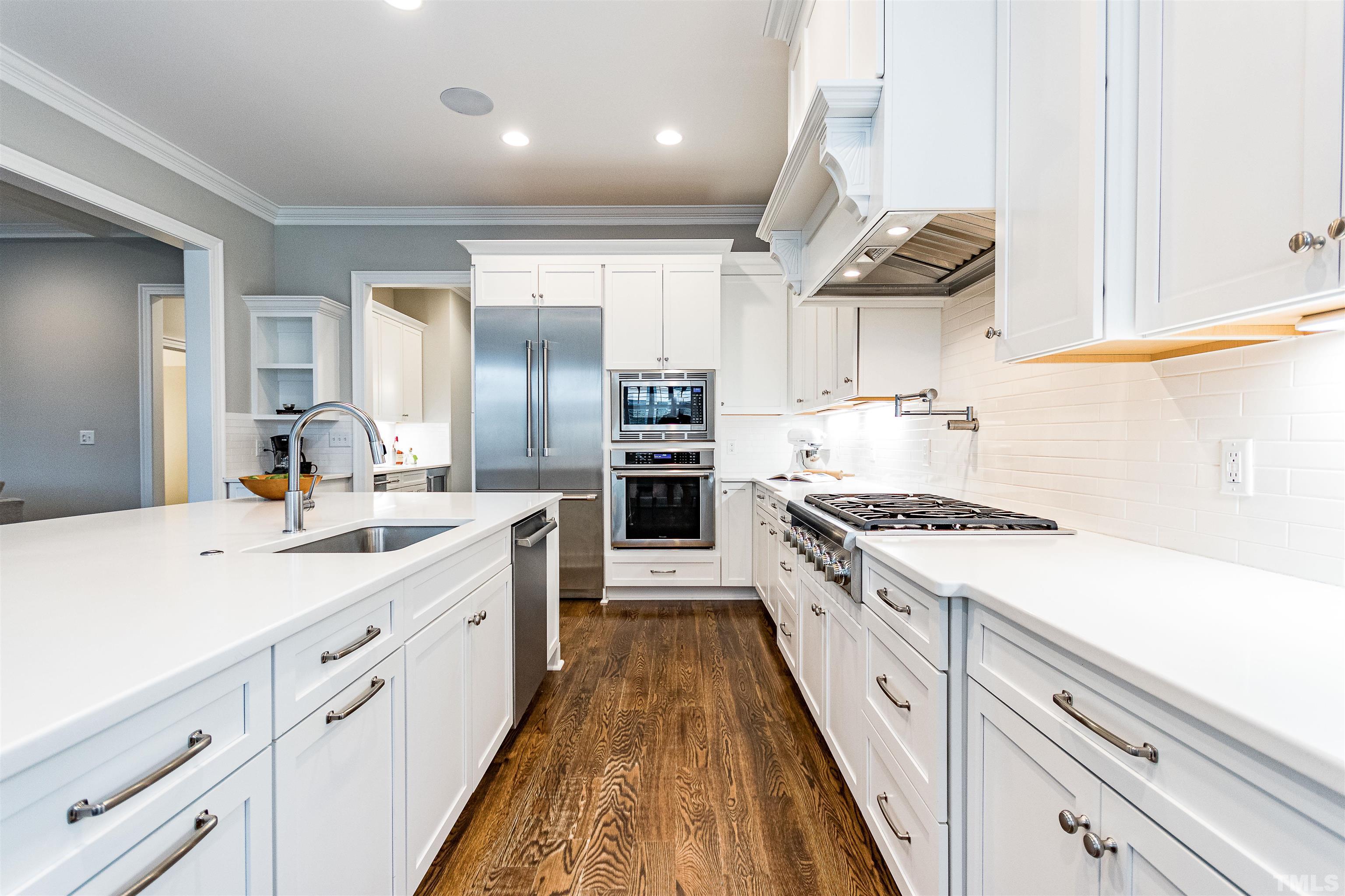 641 Cranbrook Road Raleigh, NC 27609 - Photo 13 of 39 a large kitchen with stainless steel appliances granite countertop a lot of counter space and wooden floors