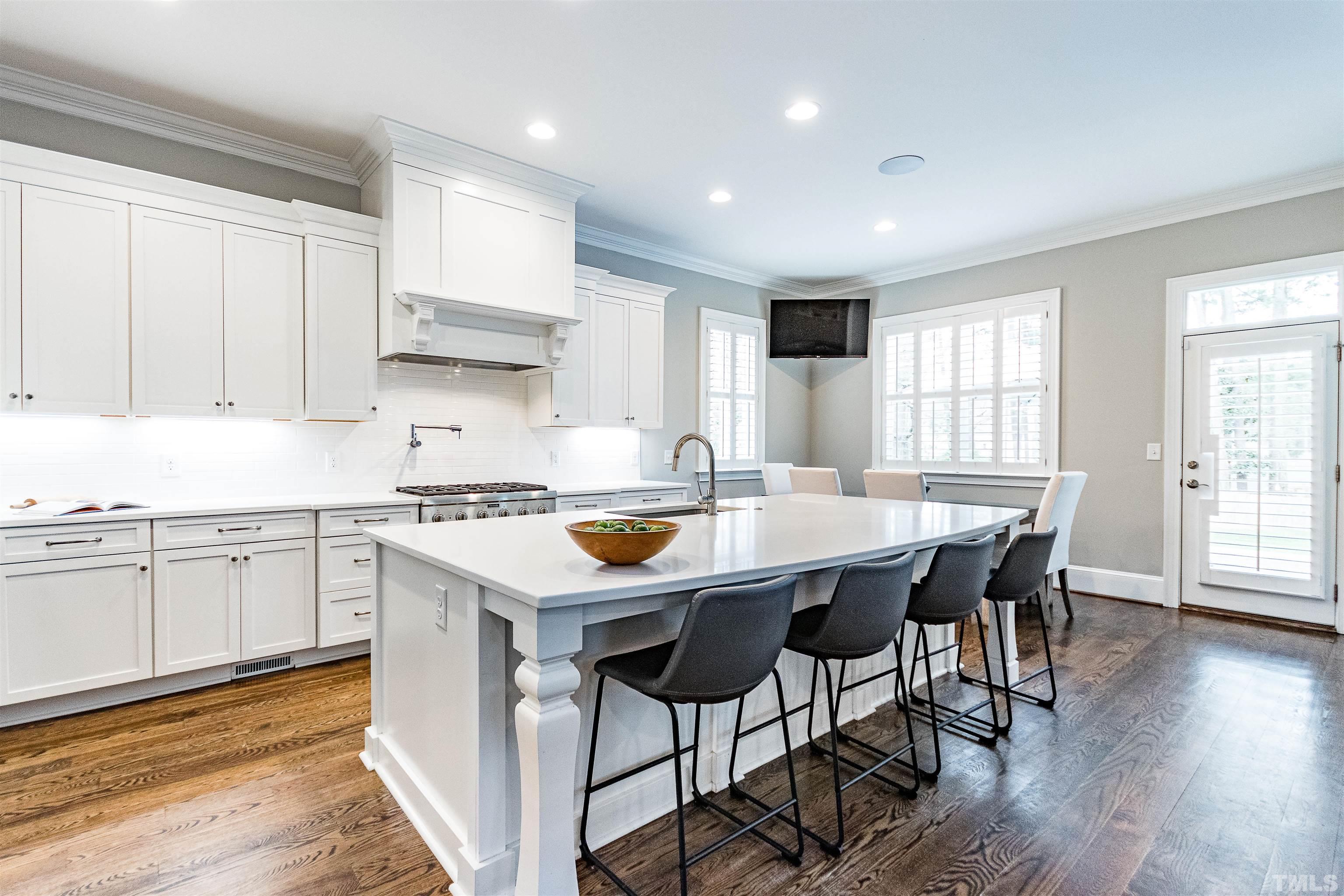641 Cranbrook Road Raleigh, NC 27609 - Photo 10 of 39 a kitchen with stainless steel appliances granite countertop a stove a sink a microwave a refrigerator and white cabinets with wooden floor